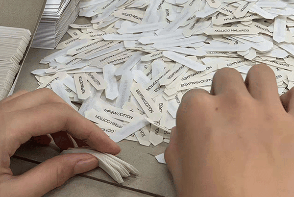 Hand inspection for woven label defects edge threads alignment